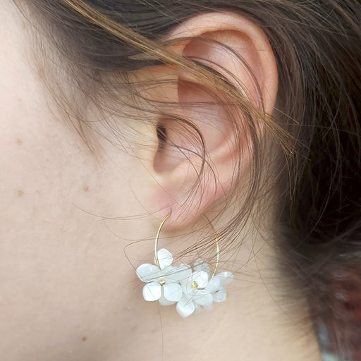 White floral earrings on 25mm golden steel hoops (1 pair)